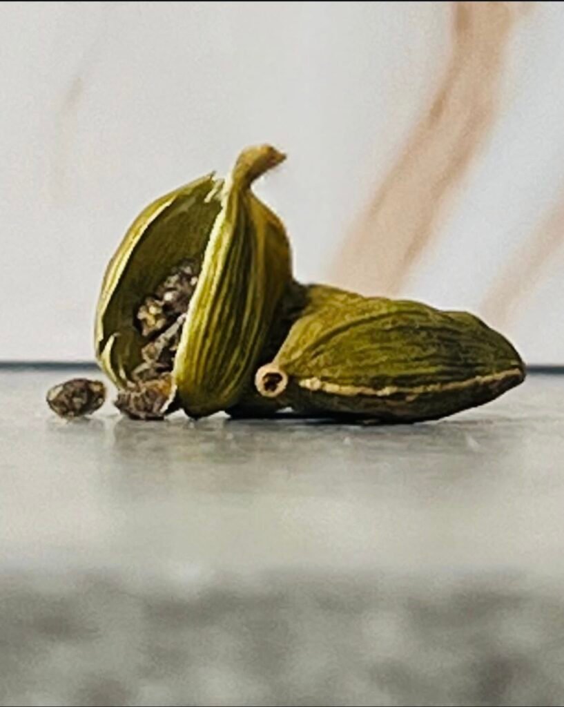 Cracked open cardamom pod with seeds exposed